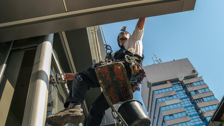 Industrial climbing - Facade Cleaning Service.Workers hanging on climbing ropes. 