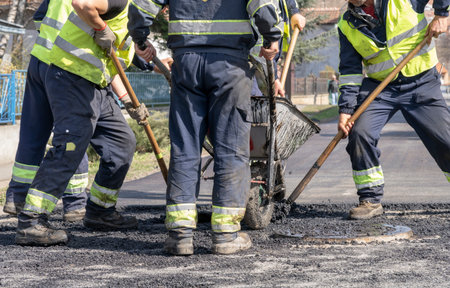 Road Construction Workers Leveling Asphalt - Teamwork