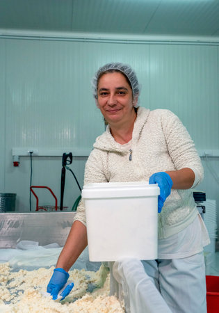 Smiling Female Worker on Cheese Production Line in a Dairy Plant