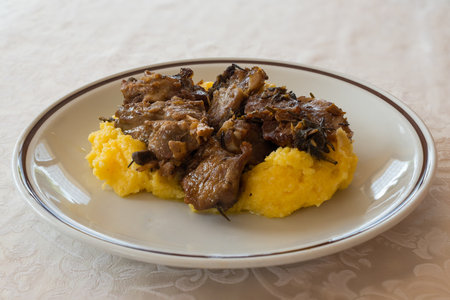 in the picture typical italian food ,roasted goat and Polenta on white dish at restaurant.の写真素材