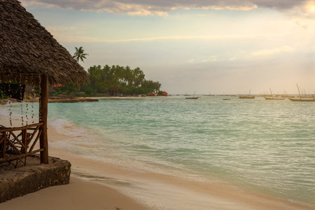 A beautiful beach with Several fishing boats  anchored at sunset with sunbeams.Zanzibar coast,Tanzania.の写真素材