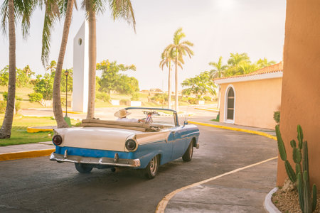 Vintage classic american blu car,driver with cowboy hat while with his old American car leaves the parking lot of the hotel.の写真素材