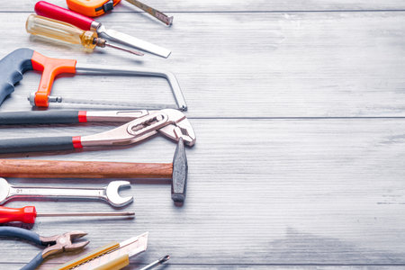 Screwdriver,hammer,tape measure and other tool for construction tools on gray wooden background with...