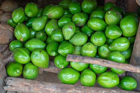 Green avocado stack at grocery on tropical marketplace outdoor,Samana peninsula,Dominican republic.