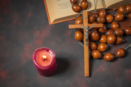 Big wooden Rosary beads and crucifix cross with jesus, red candle and bible book, spiritual atmosphere, religion concept.の写真素材