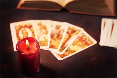 Tarot cards with candlelight and book on the darkness background, Halloween and future reading concept.の写真素材