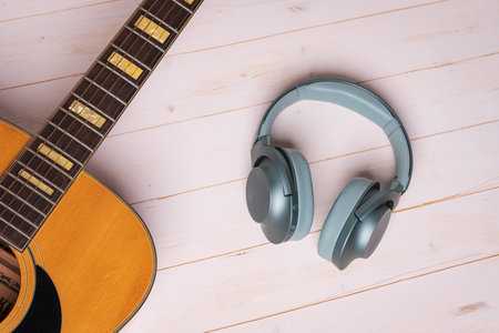 view from above of guitar and green headphones on wooden background, closeupの写真素材