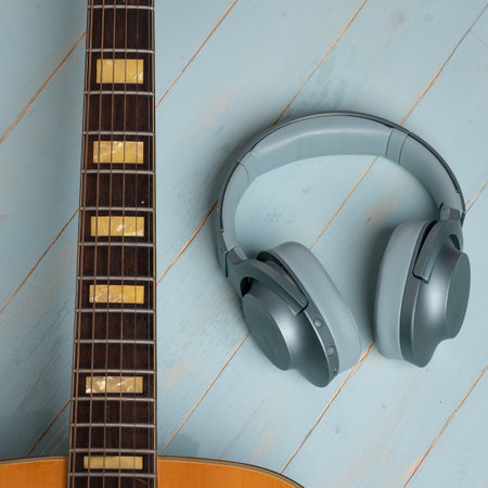 view from above of guitar and green headphones on wooden background, closeupの写真素材