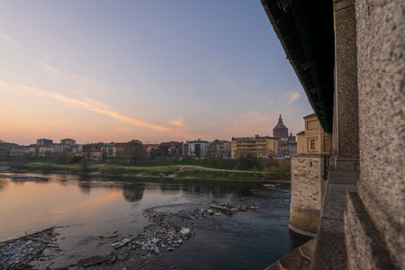 Skyline of Pavia , Ponte Coperto(covered bridge) is a bridge over the Ticino river in Pavia at sunset, Pavia Cathedral background, Italyの写真素材