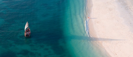High angle of view of dhow boat in the green ocean and wonderful white sandy beach, copy space,...