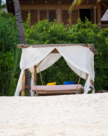 White beach canopy at sunset. Luxury beach tents at luxurious beach resort. Summer beach concept,...