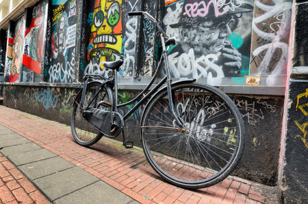 Dutch typical bicycle with graffiti on the background in Amsterdamのeditorial素材