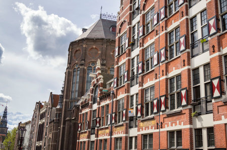 Colorful typical Dutch building and Saint Nicholas Church in Amsterdam, The Netherlandsのeditorial素材