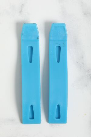 bicycle tire reapair tools on white marble background. Blue and chrome item.
