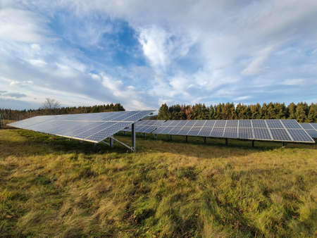 Solar cells on a meadow with blue sky with clouds. Solar panels, photovoltaic, alternative energy...