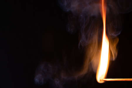 Macro shot of a burning match. Studio shot isolated on black background. Texture, wallpaper