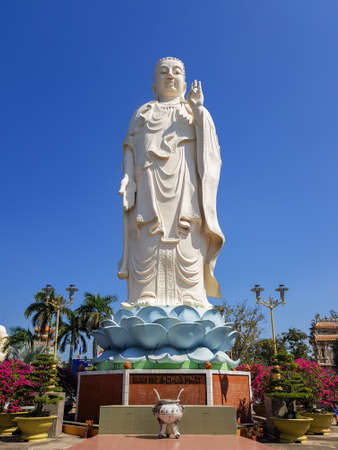 Standing Buddha Statue at the Vinh Trang Temple in Mytho City. Mekong Delta, Vietnam. Translation: "I place my faith in Buddha."の写真素材