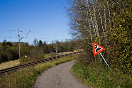 In the middle of nowhere this train passage is situated. The slightly bent sign is a nice twist to a common scene.の写真素材