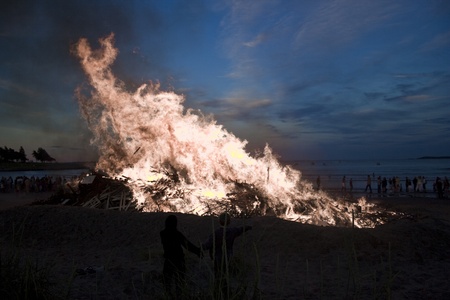 Because of a slight wind the fire is grasping for the upper corner. The two kids near the fire seems unaffected by the strong heat.のeditorial素材