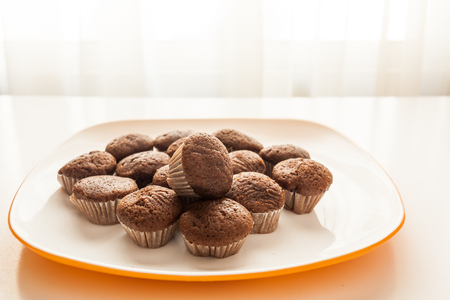 Tasty muffins in the plate on the table near to window with natural sun lightの写真素材