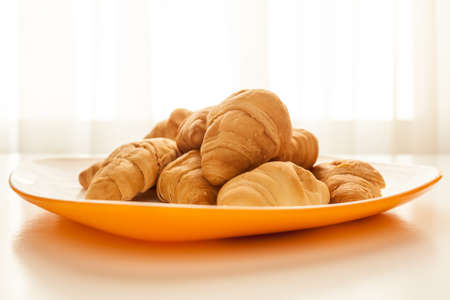 Mini croissants in a plate on a table with natural lightの写真素材