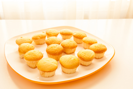 Tasty muffins in the plate on the table near to window with natural sun light.の写真素材