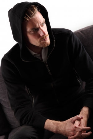 A man in a hoodie looking away from camera. White background.の写真素材