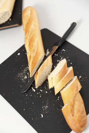 Closeup of sliced bread, on a cutting board. Grey background.の写真素材