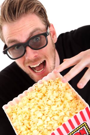 Man in 3D-glasses with a popcorn bucket, sitting down  White background の写真素材