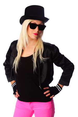 Cool woman standing with pink pants and a black jacket  Wearing a black top hat and black sunglasses  の写真素材