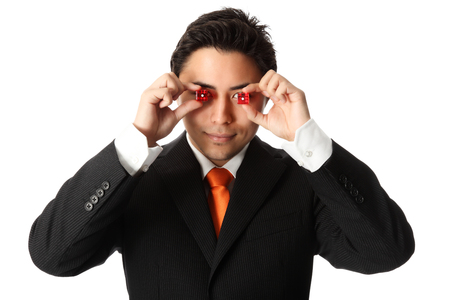 Attractive businessman in a suit and tie, holding red dices, taking a risk  White background の写真素材