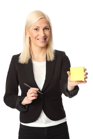 Attractive business woman standing wearing a white shirt and black jacket  Writing on a note pad  White background の写真素材