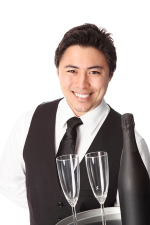 Attractive waiter with bottle and glasses, wearing a black vest の写真素材