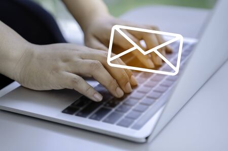 Contact us or Customer support hotline people connect. Businessman using a laptop with the (email, call phone, mail) icons.の写真素材