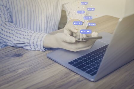 Person using a social media marketing concept on mobile phone with notification icons of like,...