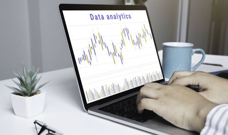 Businessman using a laptop computer with data analytics and statistics information business...