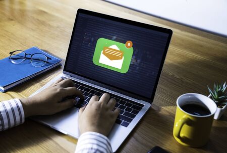 Person using a laptop computer with email communication connection message online and chat on social media with global letters concept. Laptop mockupの写真素材