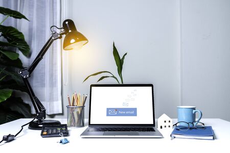 Laptop computer on white table with email communication connection message online and chat on social media with global letters concept. Laptop mockupの写真素材