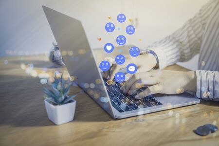 Person using a social media marketing concept on laptop computer with notification icons of like, chat, message and comment above laptop keyboard.の写真素材