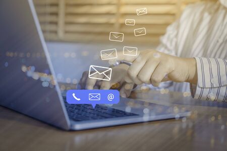 Contact us or Customer support hotline people connect. Businessman using a laptop computer with the (email, call phone, mail) icons.の写真素材
