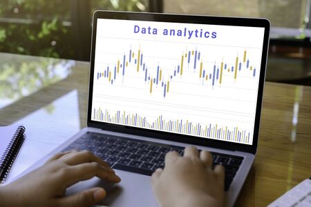 Businessman using a laptop computer with data analytics and statistics information business...