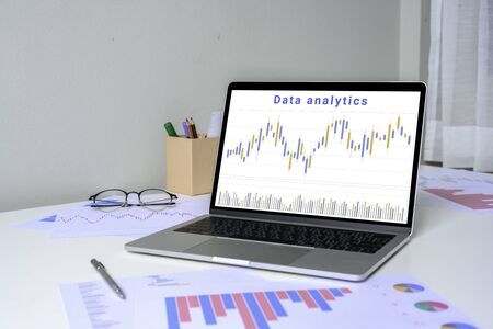 Laptop with data analytics and statistics information business technology on table top. mockup