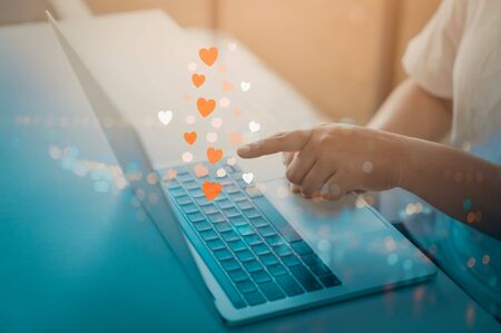 Woman hands using laptop computer with social love website for valentine's day.の写真素材