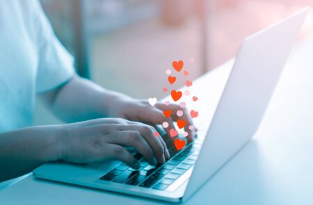 Woman hands using laptop computer with social love website for valentine's day.の写真素材