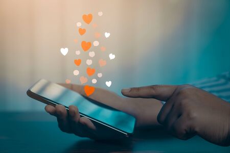 Woman hands using mobile smartphone with social love app for valentine's day.