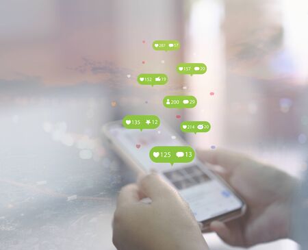 Person using a social media marketing concept on tablet computer with notification icons of like,...