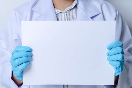 Doctor holding a blank white paper. Copy space for text and banner.の写真素材