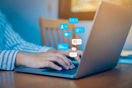 Person using a social media marketing concept on computer tablet with notification icons of like,...