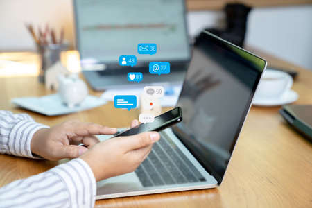 Person using a social media marketing concept on mobile phone with notification icons of like,...