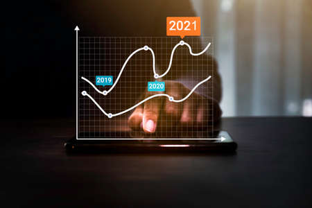 AR (Augmented reality) financial charts showing growing revenue in 2021 floating above digital...